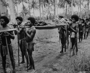 New Guinea natives carry a wounded 32nd “Red Arrow” Division Soldier away from the front lines near the village of Simeni Nov. 25, 1942 during the Buna campaign. U.S. Army Signal Corps photo