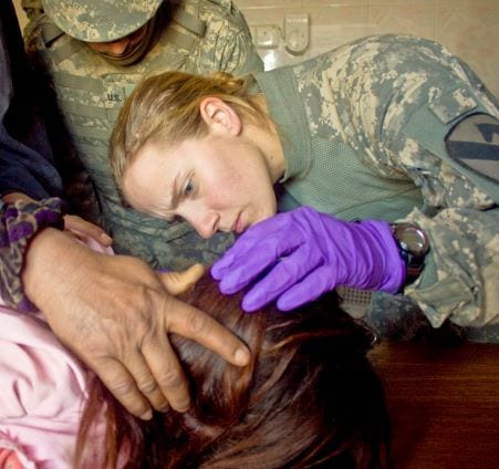 Rachelle Halaska giving medical treatment to a child in Iraq.