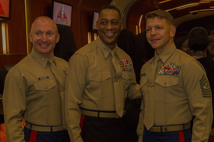 Sergeant Major Corcoran appears on the right. Major General Craig C. Crenshaw, commanding general of Marine Corps Logistics Command, stands in between Maj. Christopher M. Siekman, commanding officer of Recruiting Station Baton Rouge, and Sgt. Maj. Shawn Corcoran, sergeant major of Recruiting Station Baton Rouge, as they pose for a photo during the Bayou Classic Welcome Reception Nov. 25, 2016, at the West Bunker Club in the Mercedes-Benz Superdome, New Orleans, Louisiana. The appearance of U.S. Department of Defense (DoD) visual information does not imply or constitute DoD endorsement. 3015184. Public domain.