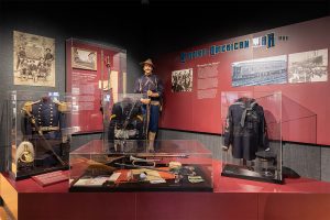 Military Uniforms from the Spanish American War in a museum gallery.