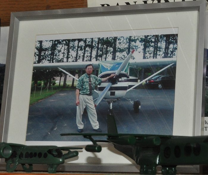 Photograph of a photograph of Nao Tou Lor standing in front of his Cessna 150 aircraft
