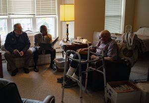 WDVA Secretary James Bond, Wisconsin Veterans Museum Director Christopher Kolakowski, and Lt. Col. (Ret.) Harry Baker exchange stories in visit to the WWII veteran at his home.