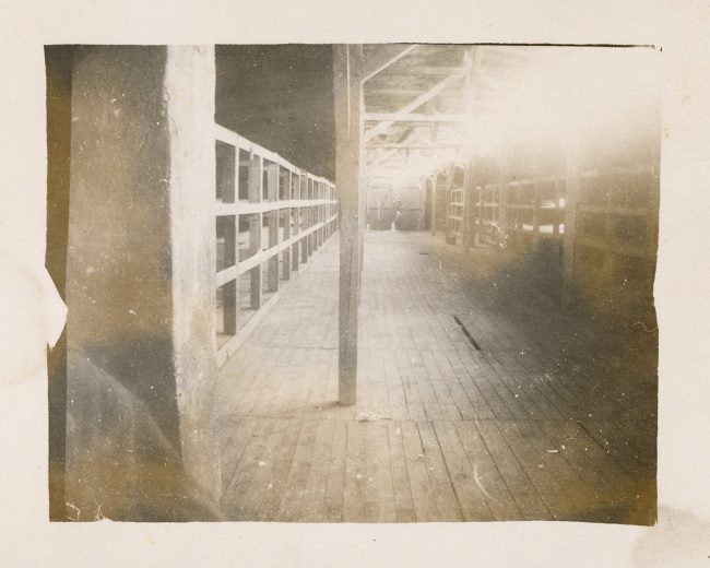 Photo of The interior of the barracks shows wooden bunks at Buchenwald.