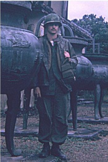 Man in green uniform standing outside