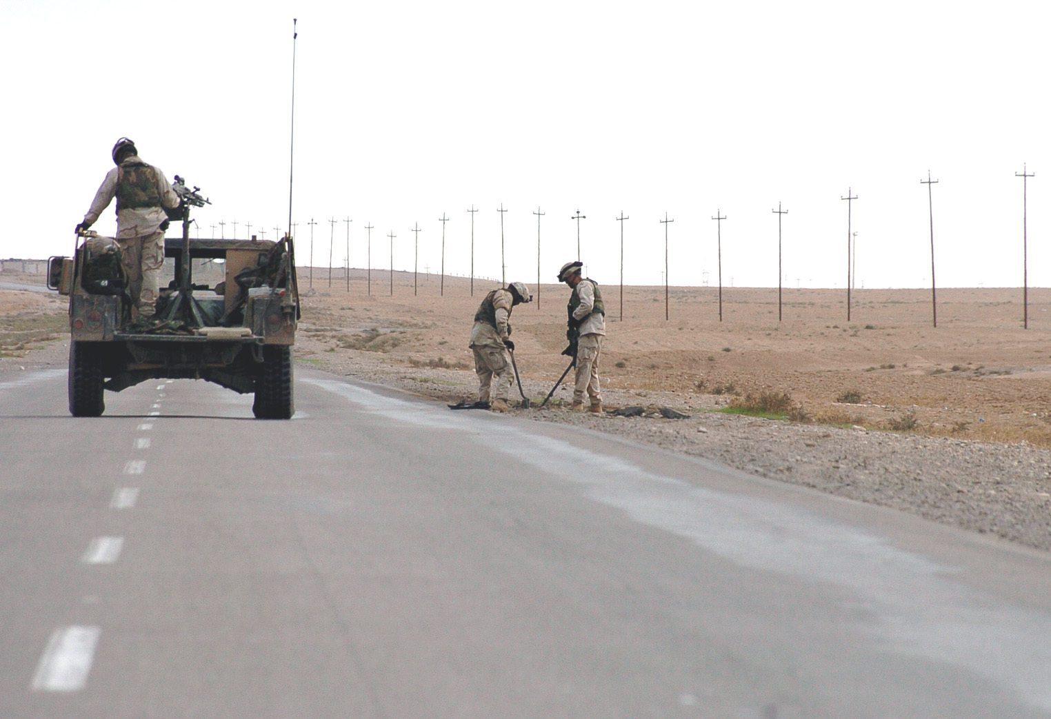 Two soldiers search for IEDs in Iraq