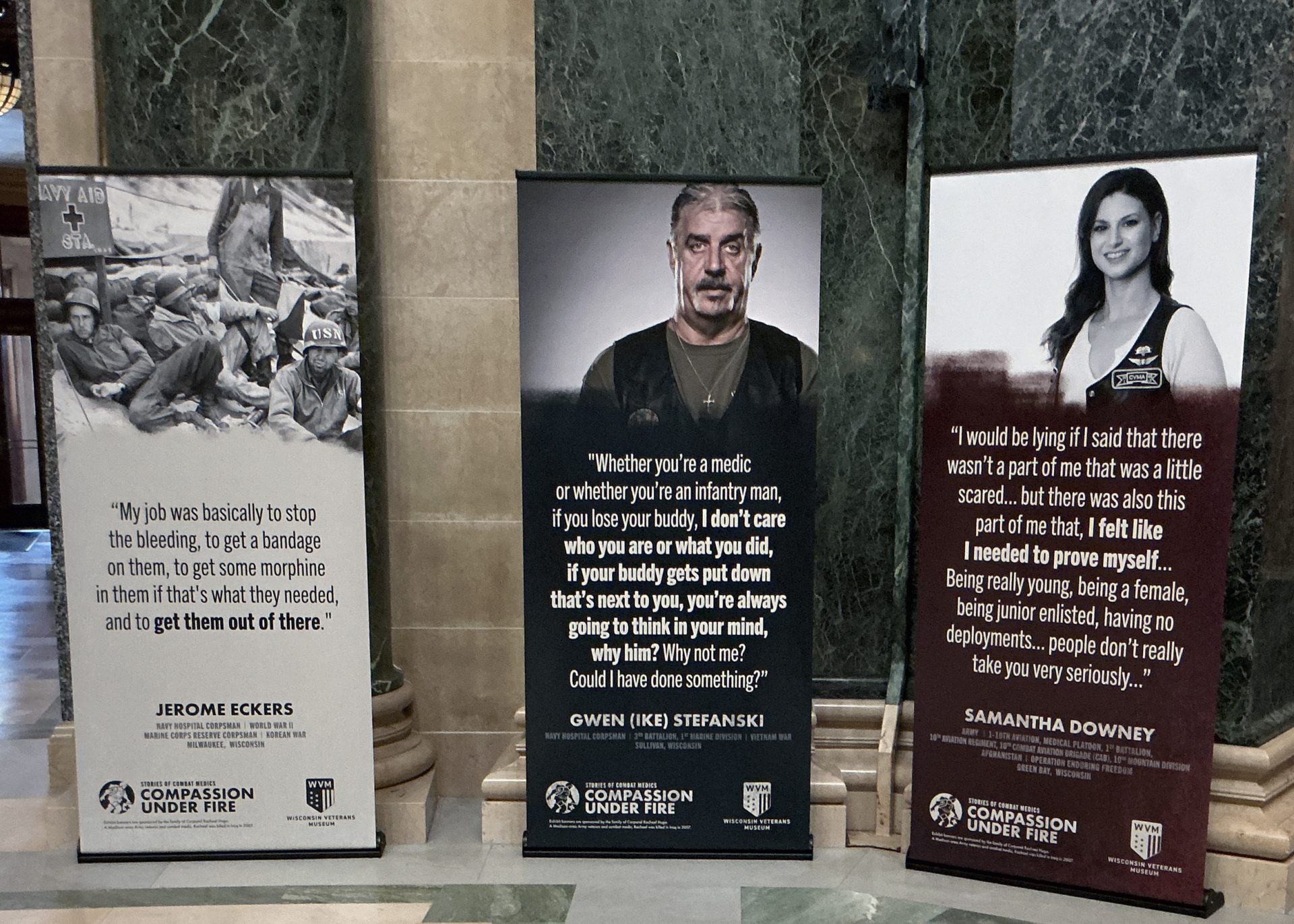 Image of three banners with images and text in an exhibition."