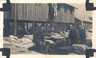 Lawrence and two friends, French and Rieves, in the midst of cleaning their barracks.